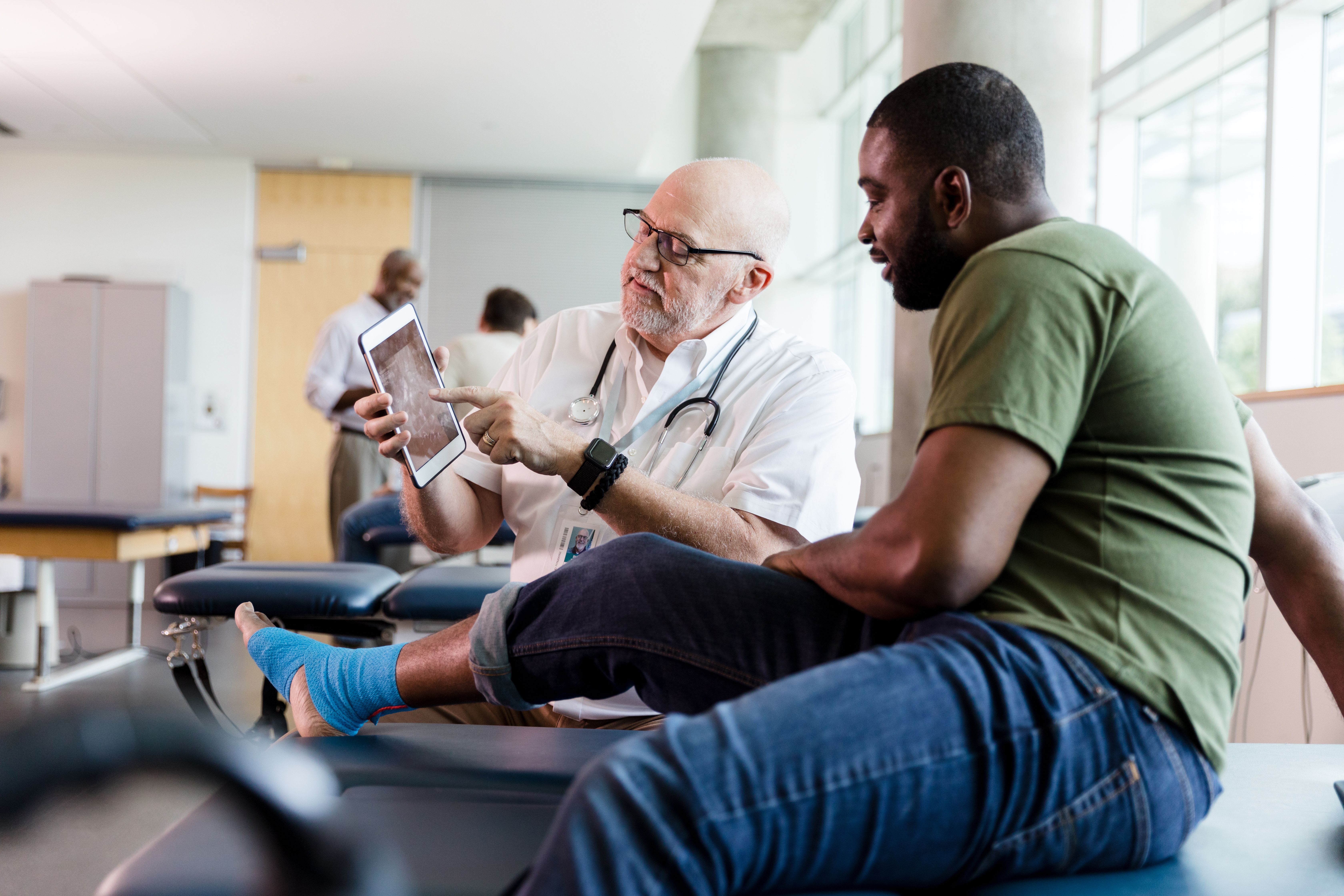 Doctor showing x-ray to rehab patient