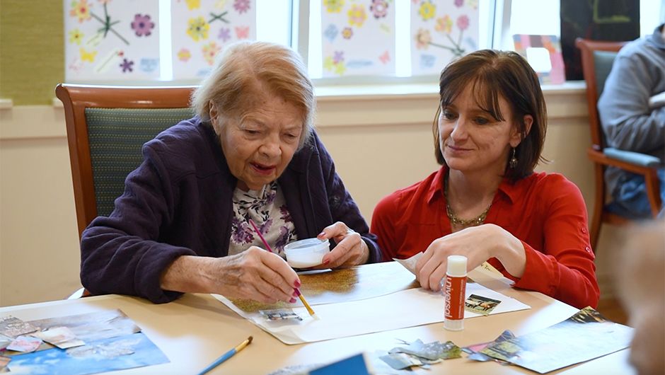 Memory care resident and staff painting 